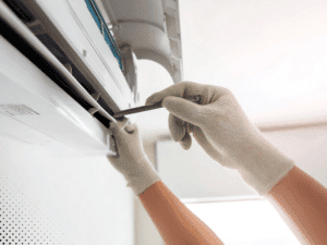 Technician checking indoor air conditioning unit filter during home inspection in San Antonio TX